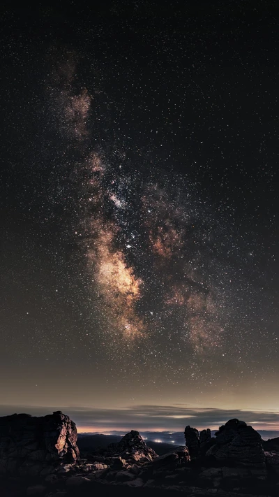 Voie lactée majestueuse sur un paysage rocheux