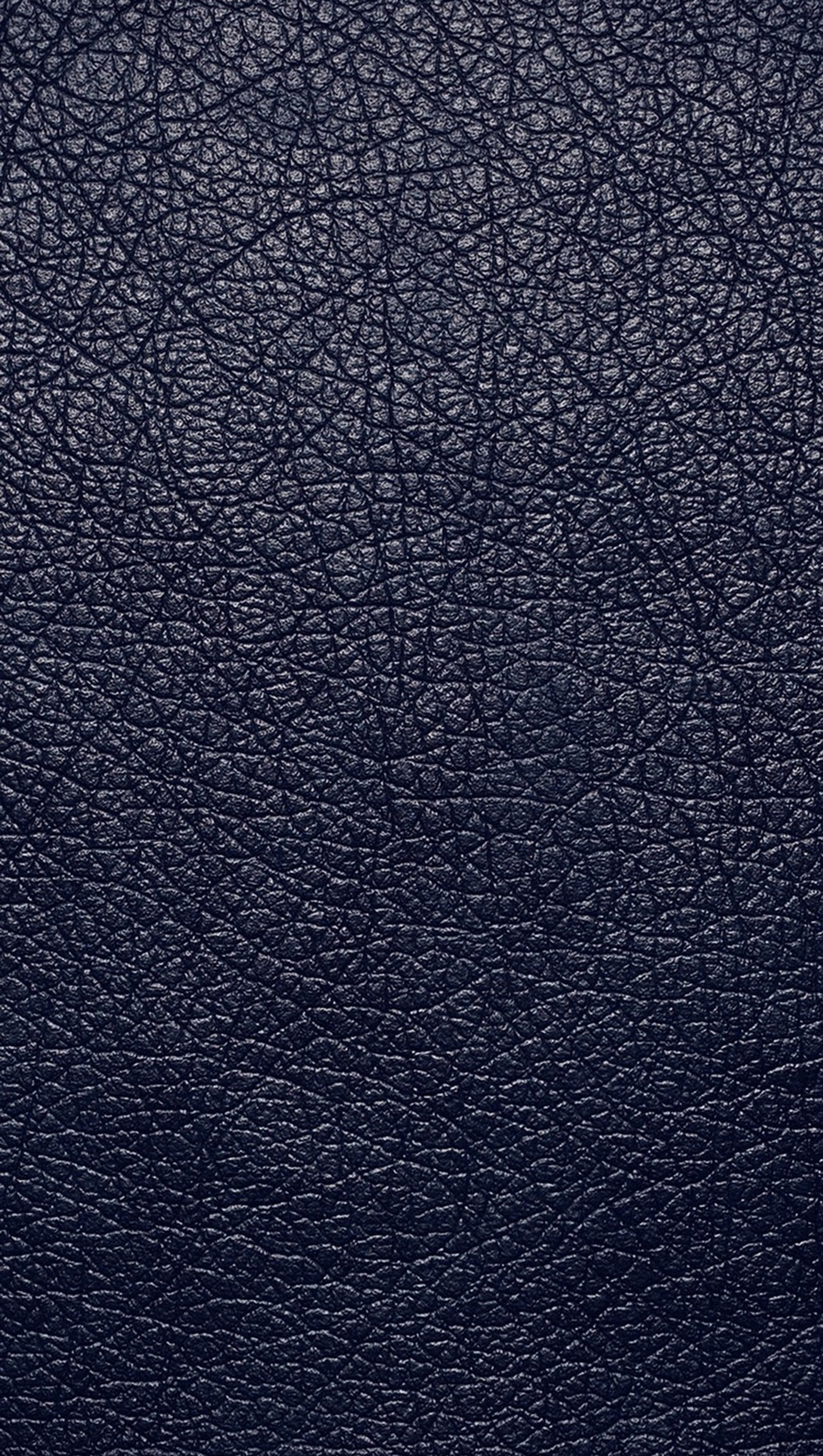 A close up of a black leather surface with a small amount of scratches (blue, leather)