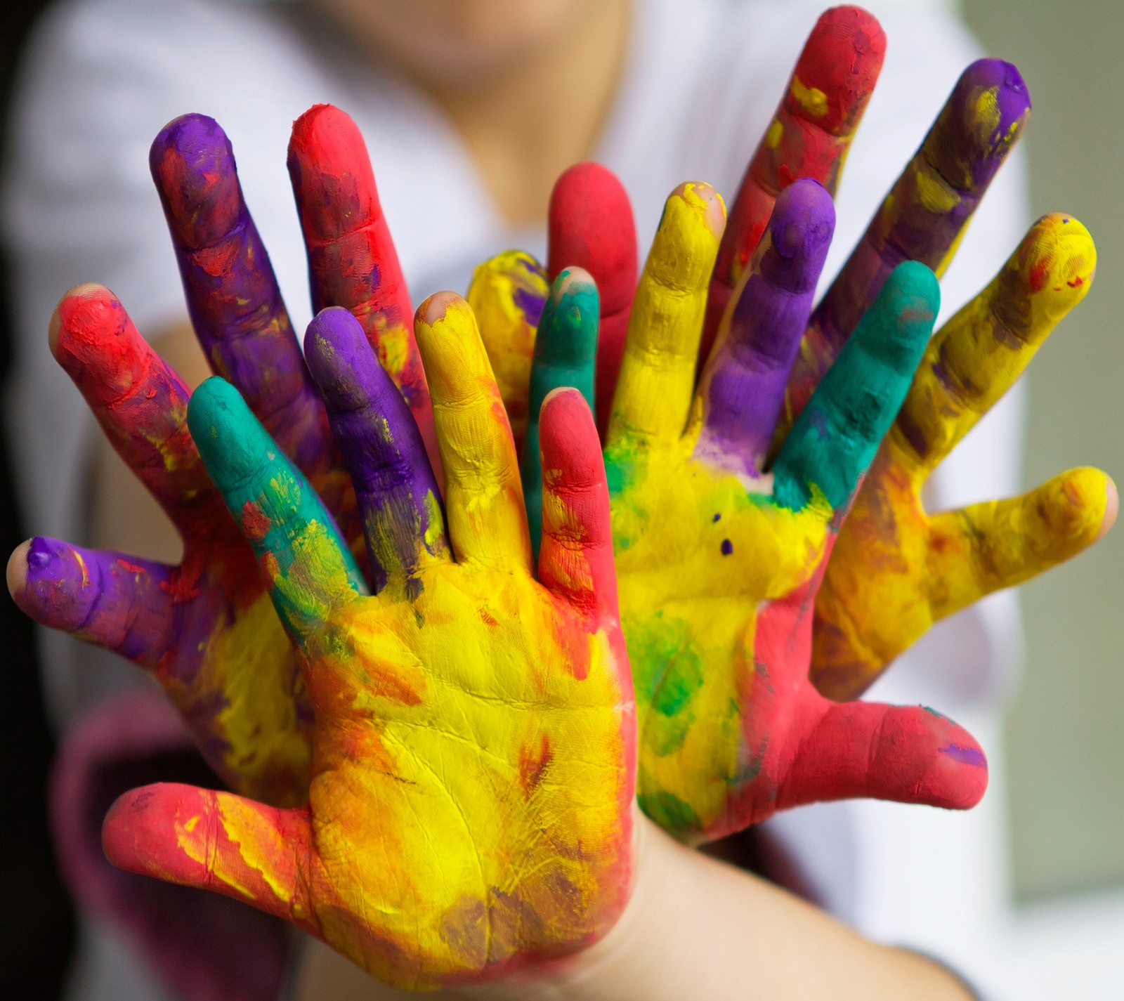 Arafed child holding up their hands with colorful paint on them (color, wallpaper)