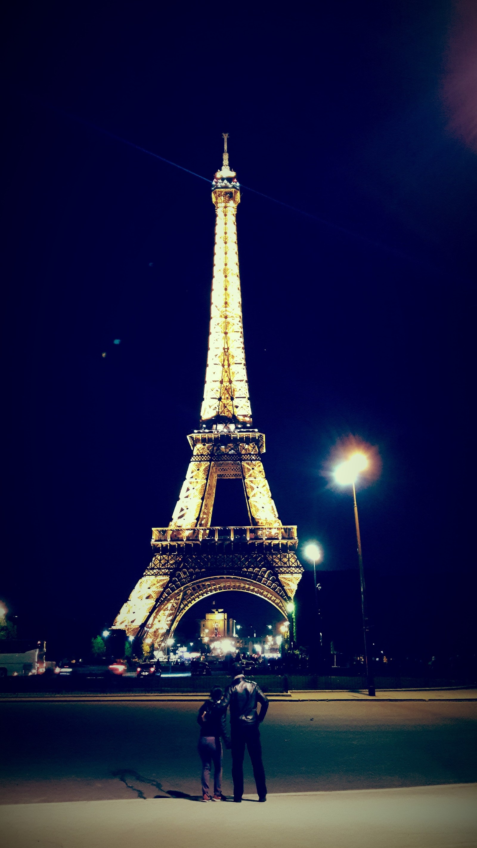 Araffes standing in front of the eiffel tower at night (eiffel, paris)