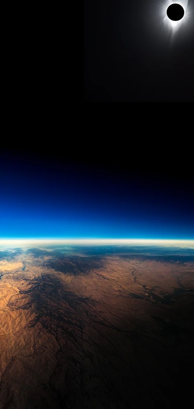 A breathtaking view of Earth from space, featuring a lunar eclipse with the moon partially obscured against the backdrop of a dark sky and the planet's illuminated horizon.