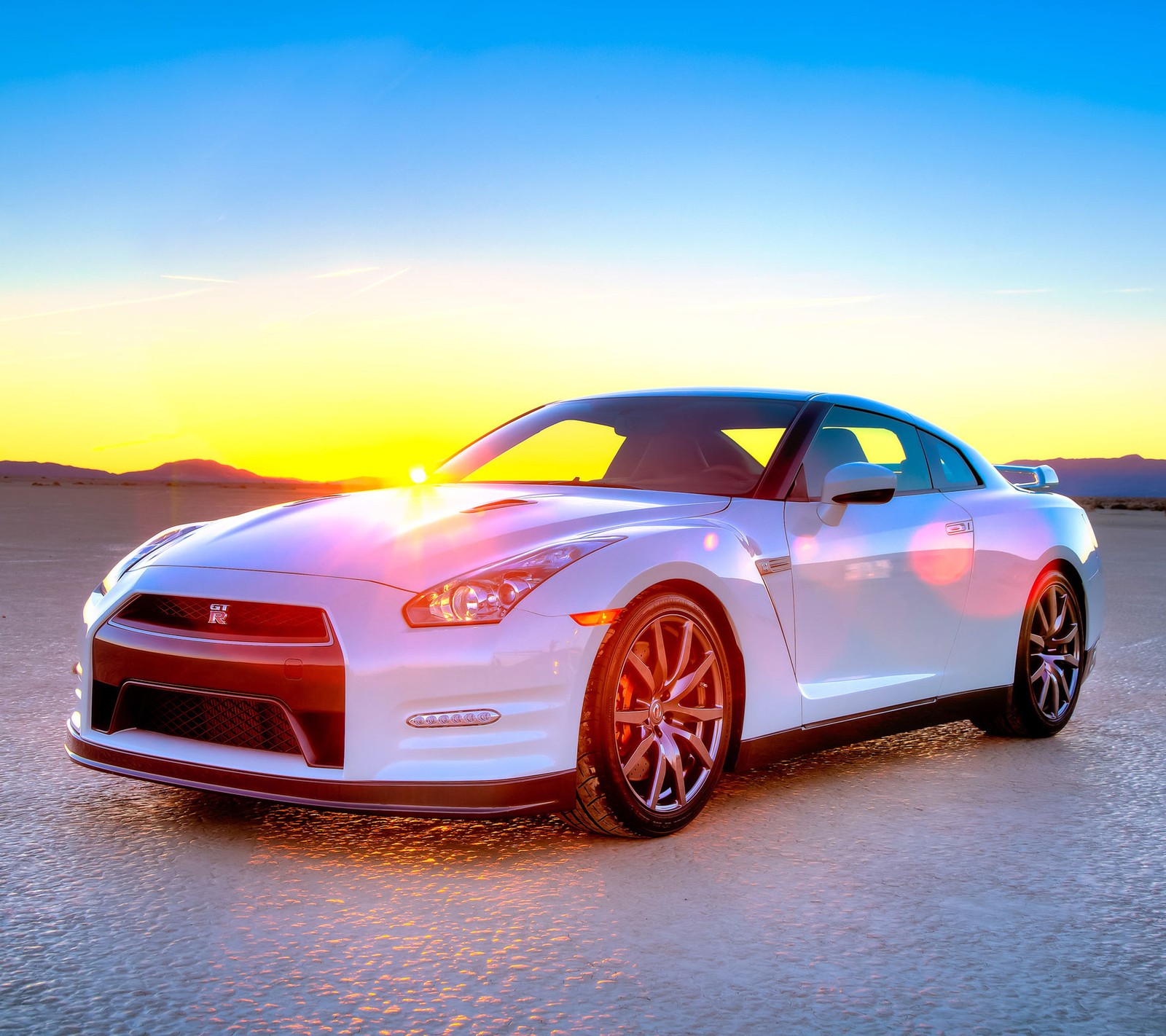 Arafed white sports car parked in a desert with a sunset in the background (america, car, engine, ferrari, gtr)