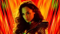 Gal Gadot en tant que Wonder Woman, mettant en valeur des teintes vibrantes d'orange et de jaune avec des cheveux longs et fluides et un regard puissant.