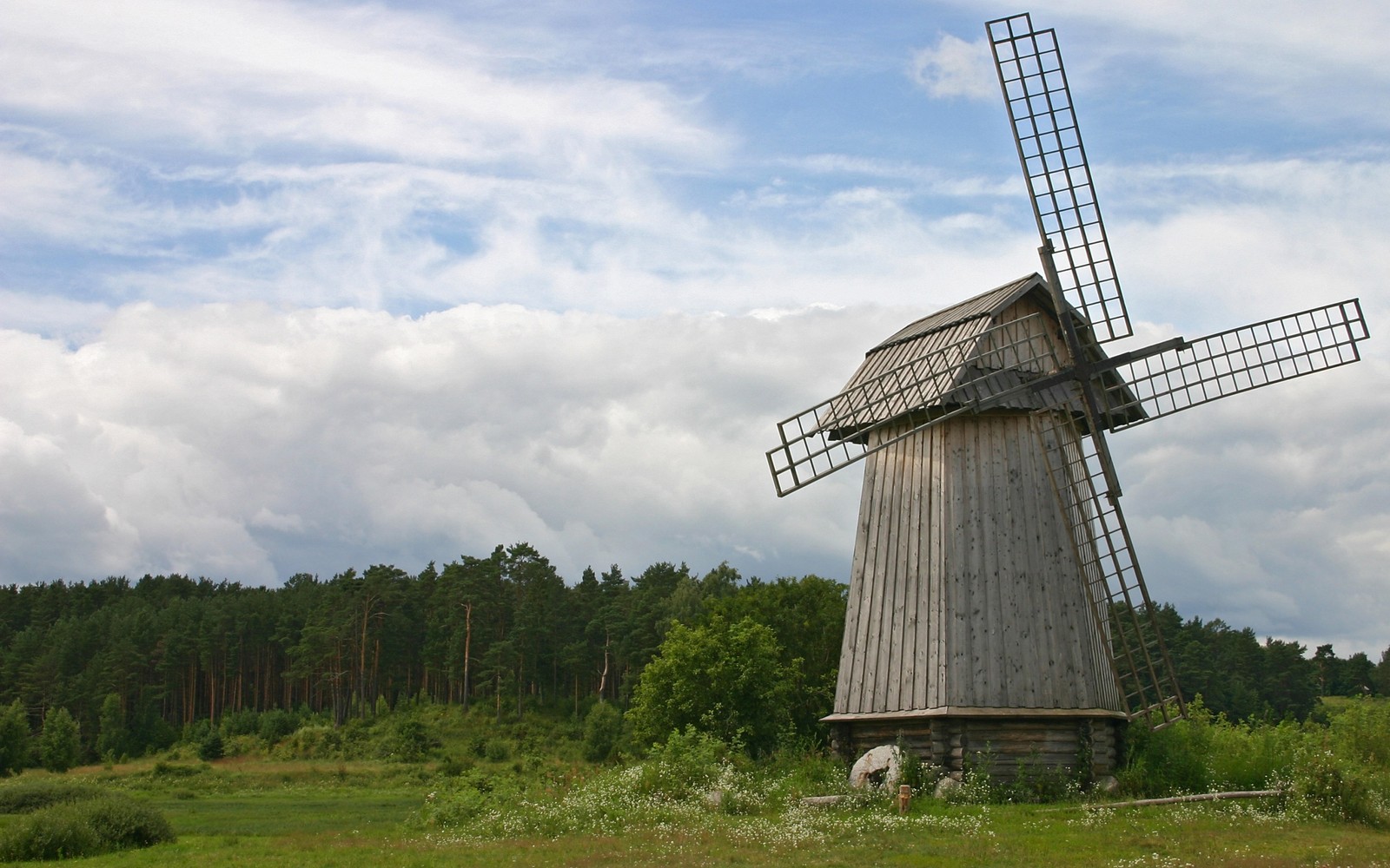 Il y a un moulin à vent au milieu d'un champ (moulin à vent, moulin, zone rurale, prairie, hauts plateaux)