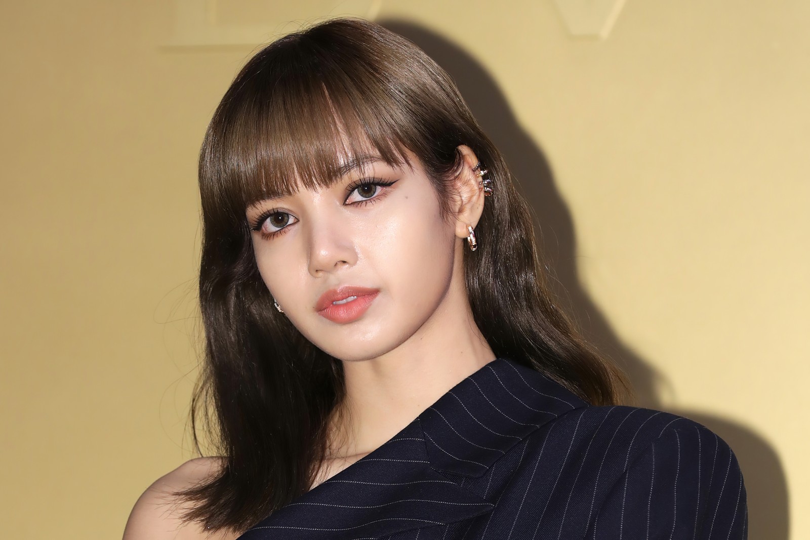 Une femme aux longs cheveux portant une robe noire et des boucles d'oreilles (lisa, portrait, blackpink, chanteur de k pop, chanteurs coréens)