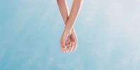 Graceful Intertwined Hands Against a Sky Background