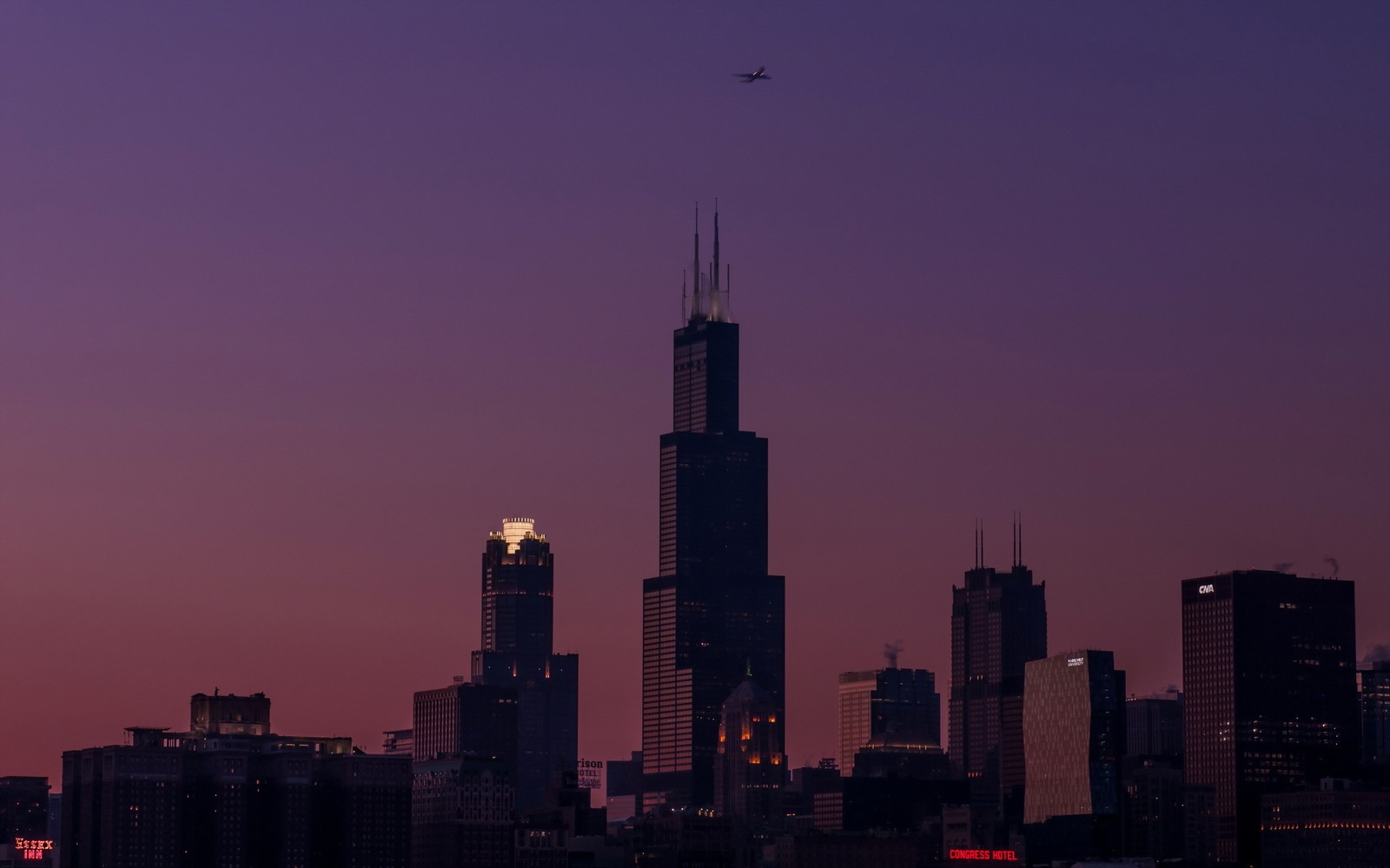 Una silueta editada de un horizonte de ciudad con un avión volando sobre él (willis tower, rascacielos, ciudad, panorama, paisaje urbano)