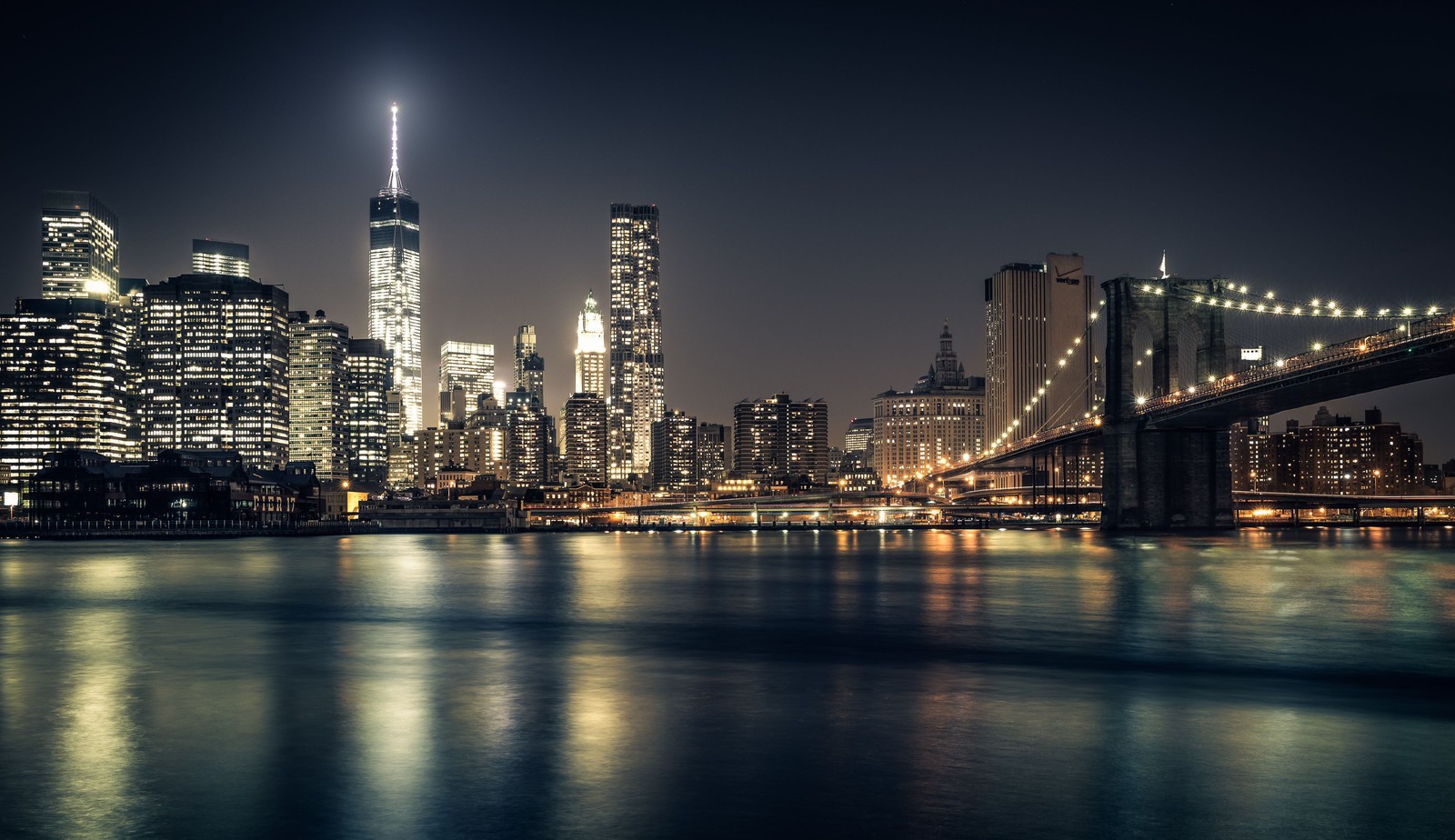 Uma vista do horizonte da cidade à noite a partir da água (ponte do brooklyn, cidade, paisagem urbana, linha do horizonte, metrópole)