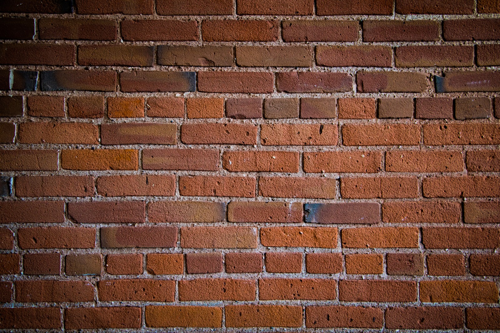 A close up of a brick wall with a small hole in it (brick, brickwork, wall, texture)