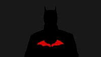 Batman-Silhouette mit rotem Emblem auf dunklem Hintergrund