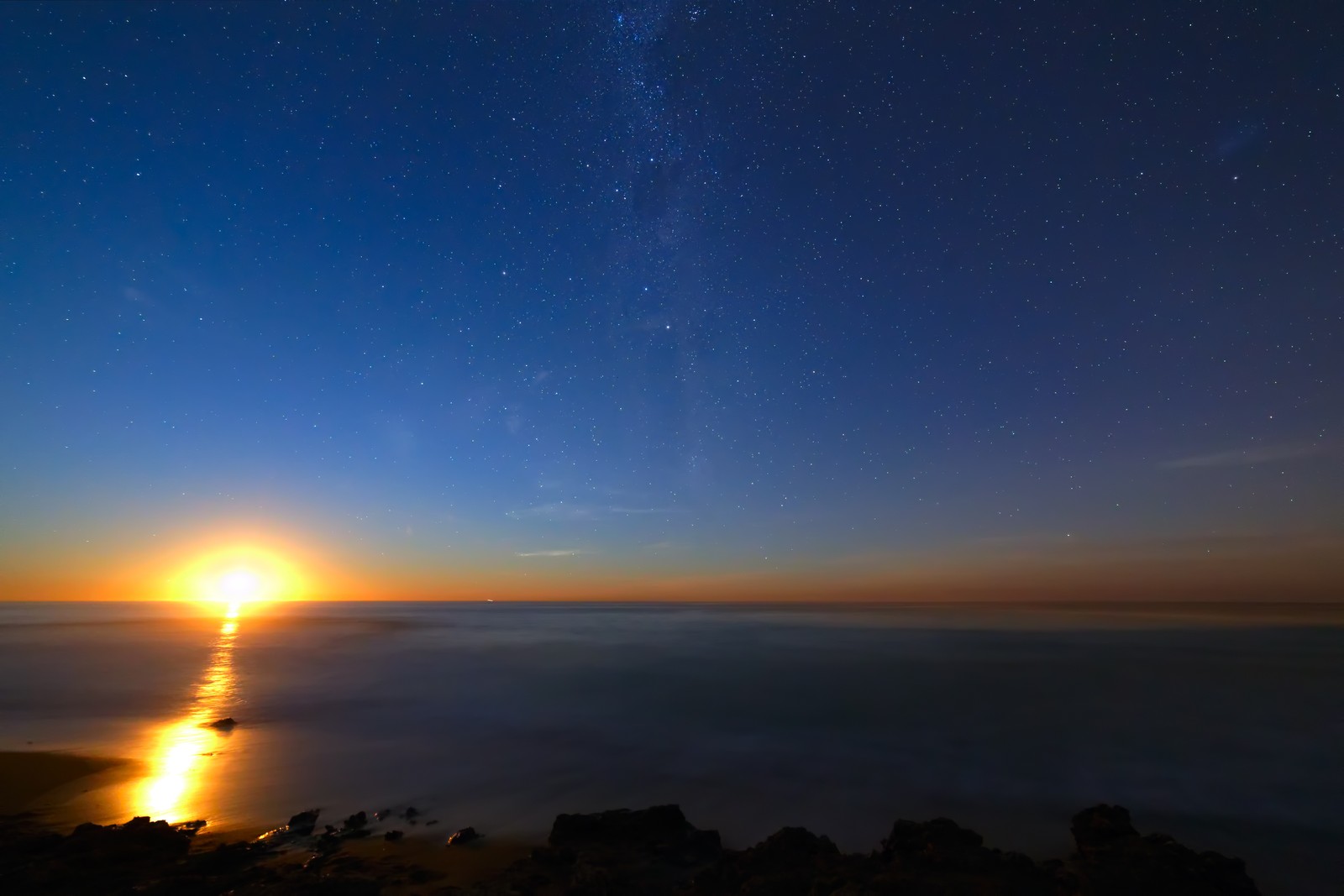 Uma vista do sol se pondo sobre o oceano e as estrelas (horizonte, noite, mar, atmosfera, nascer do sol)