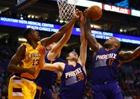 Intense basketball action featuring Phoenix Suns players battling for a rebound against Los Angeles Cavaliers on the court.