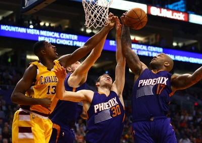 Ação intensa de basquete com jogadores do Phoenix Suns lutando por um rebote contra os Los Angeles Cavaliers na quadra.