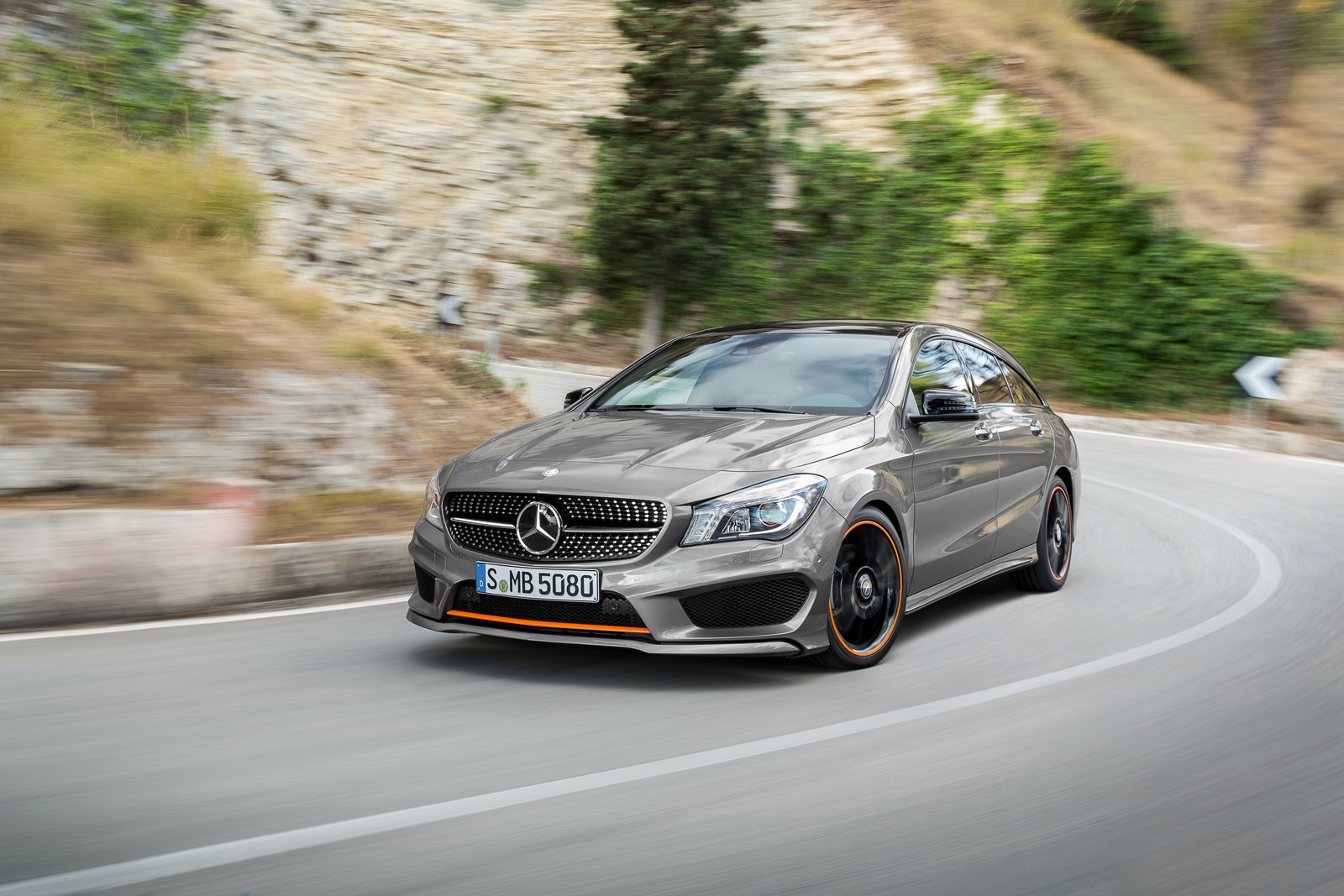 Un mercedes cla gris conduciendo por un camino sinuoso (coche, coche compacto, coche de lujo, familiar, coche mediano)