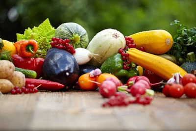 Colorida variedad de verduras y frutas frescas y orgánicas exhibidas sobre una superficie de madera, celebrando la esencia de la cocina natural y vegetariana.