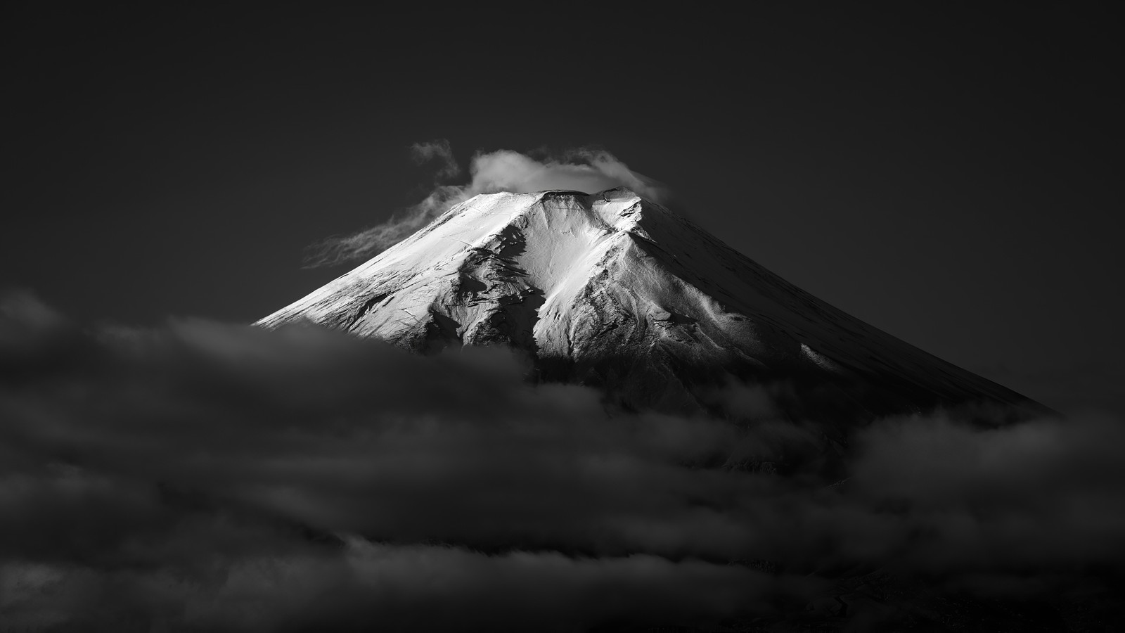 A black and white photo of a mountain with clouds in the foreground (mount fuji, volcano, mountain, black and white, cloud)