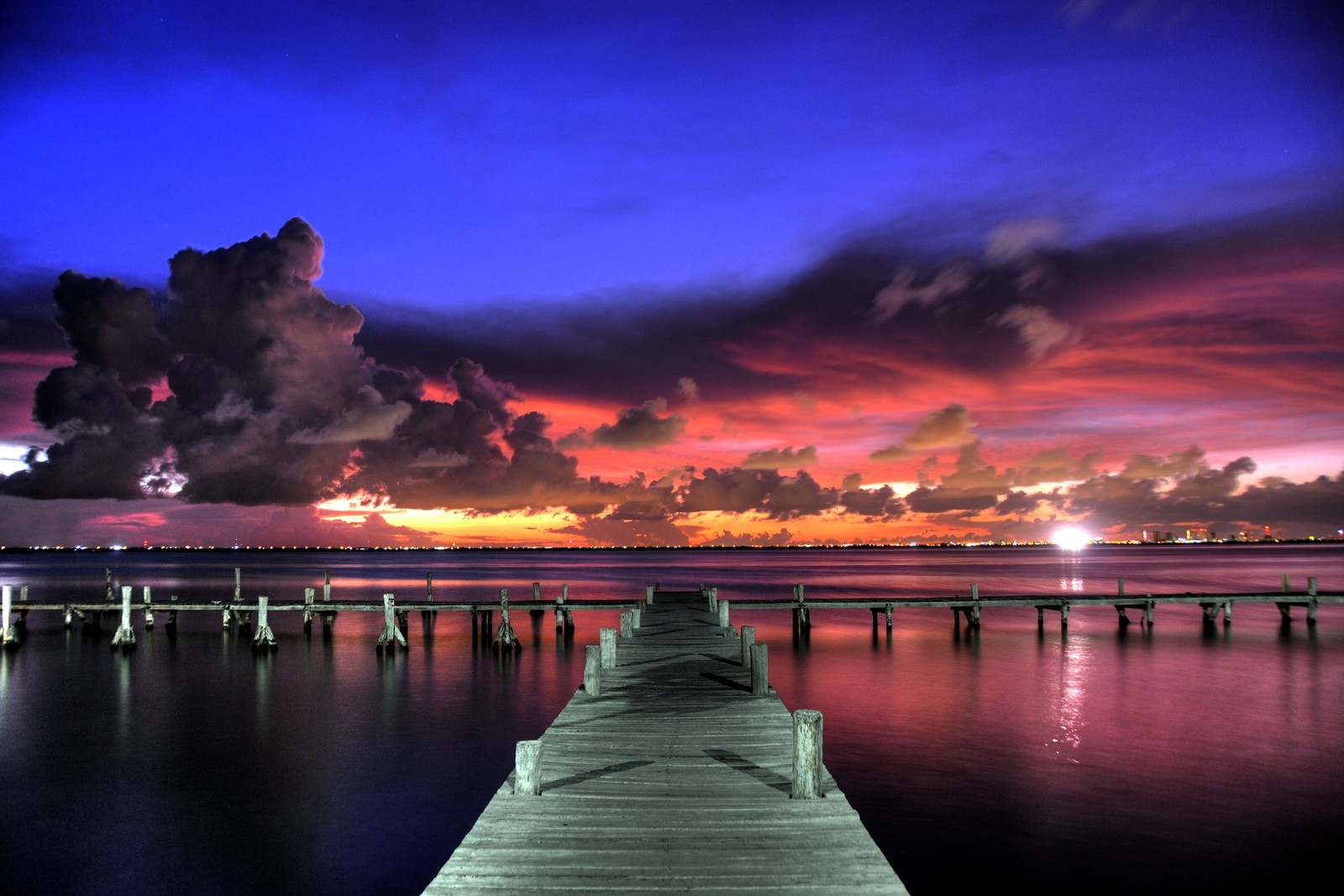 Vue floue d'un quai avec un coucher de soleil en arrière-plan (coucher de soleil, mer, crépuscule, nuage, horizon)