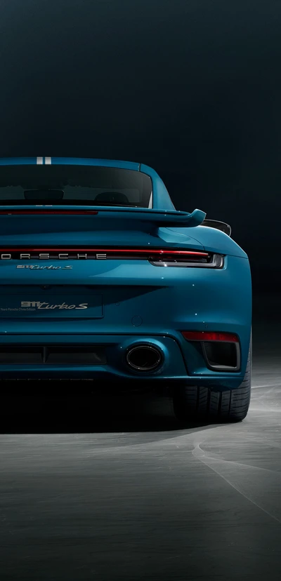 Porsche 911 Turbo S en un azul llamativo, mostrando su elegante diseño trasero y su iluminación automotriz dinámica.