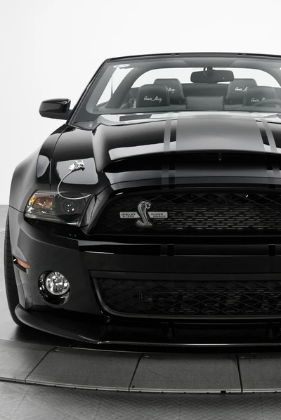 Shelby GT500 preto com grade frontal marcante e ícone de serpente.