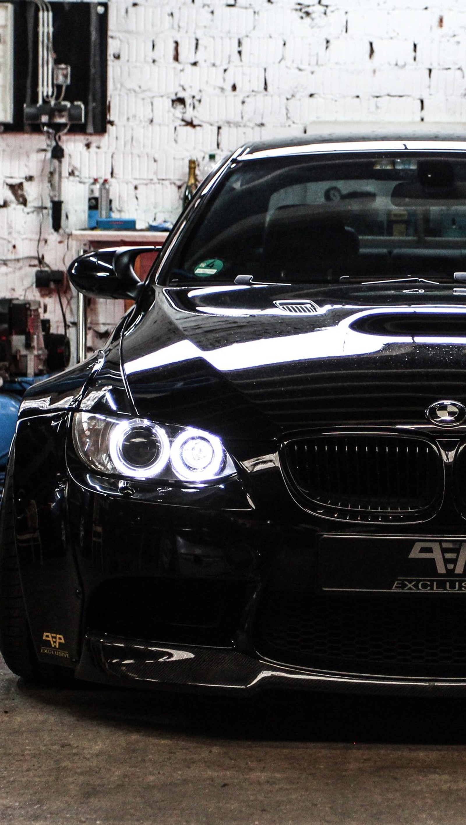 Arafed black car parked in a garage with a white wall (black, bmw, car)