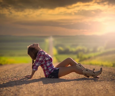 Sonnenuntergangsruhe: Ein Mädchen in Cowboy-Stiefeln auf einem ruhigen Landweg