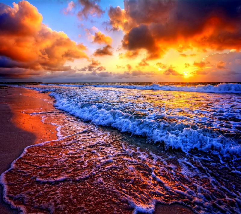 A close up of a beach with waves and a sunset (nature)