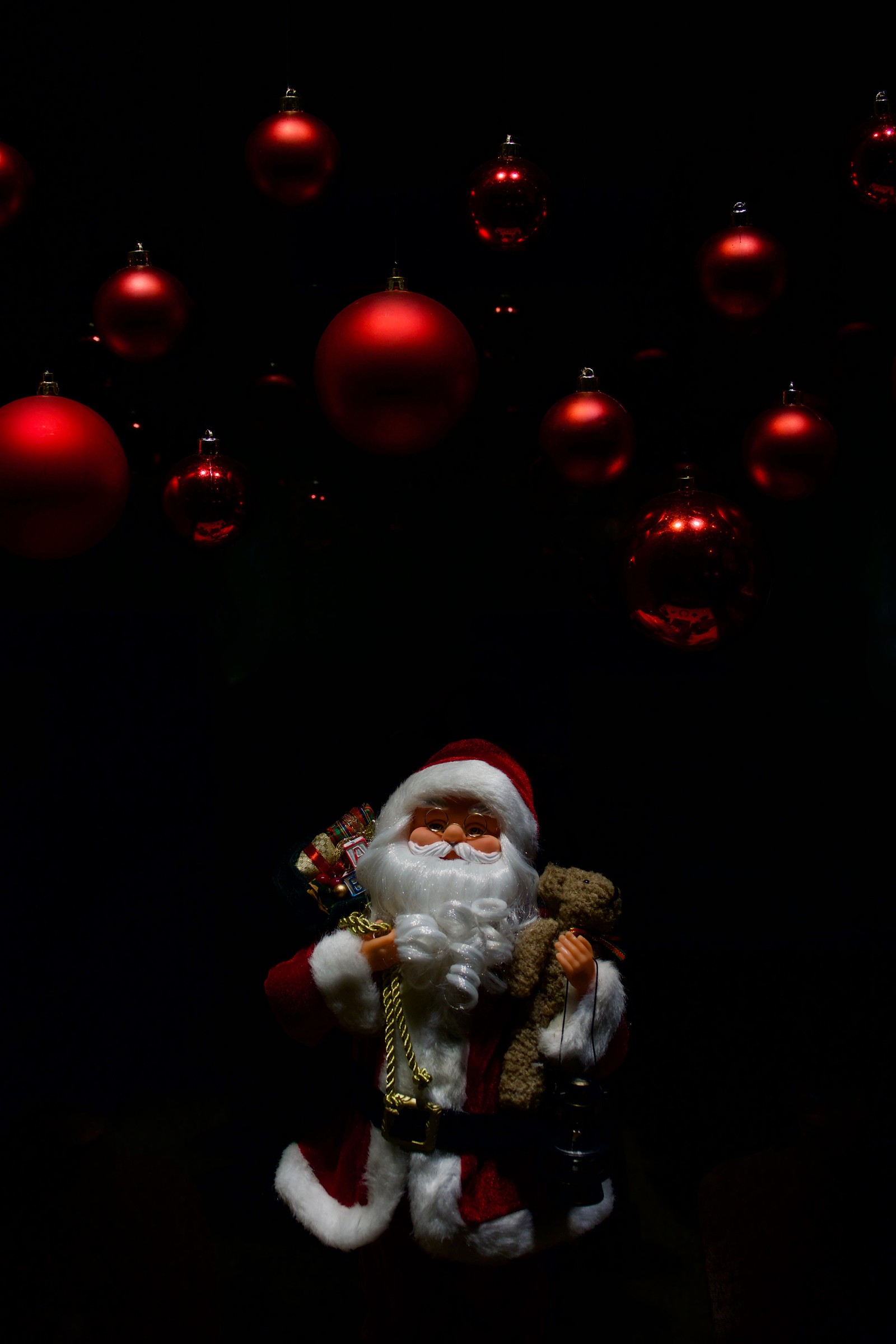 Eine kleine santa claus-figur mit einem teddybär (weihnachtstag, weihnachtsmann, neues jahr, rot, weihnachten)