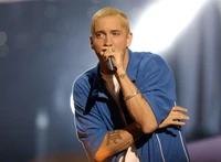 Eminem tritt leidenschaftlich auf der Bühne mit einem Mikrofon auf und zeigt seine dynamische Präsenz in der Hip-Hop-Musik.