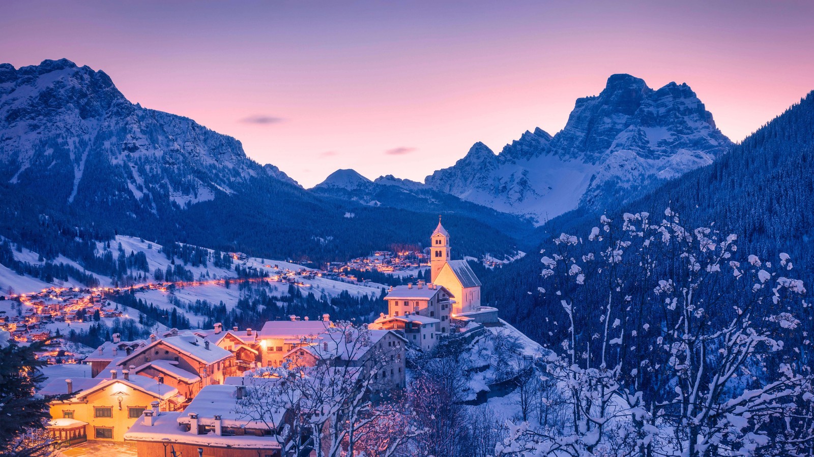 Vue d'un village dans les montagnes avec une église au crépuscule (colle santa lucia, hiver, aube, italie, vénétie)