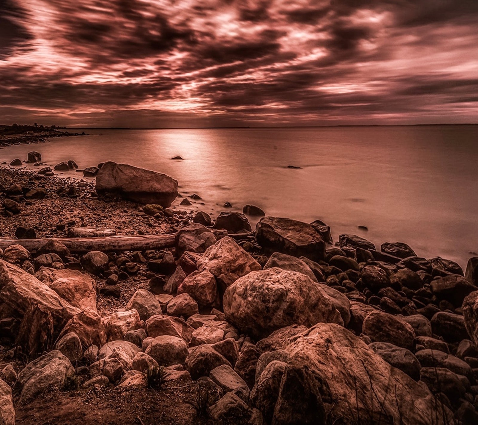 Vue d'une plage rocheuse avec un coucher de soleil en arrière-plan (paysage, nature)