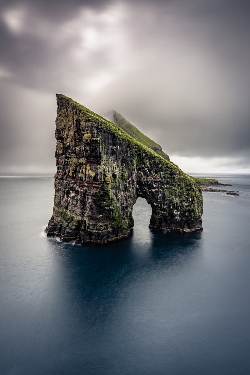 Formation rocheuse arabesque au milieu de l'océan avec un toit vert. (falaises de moher, falaise, île, mer, nuage)