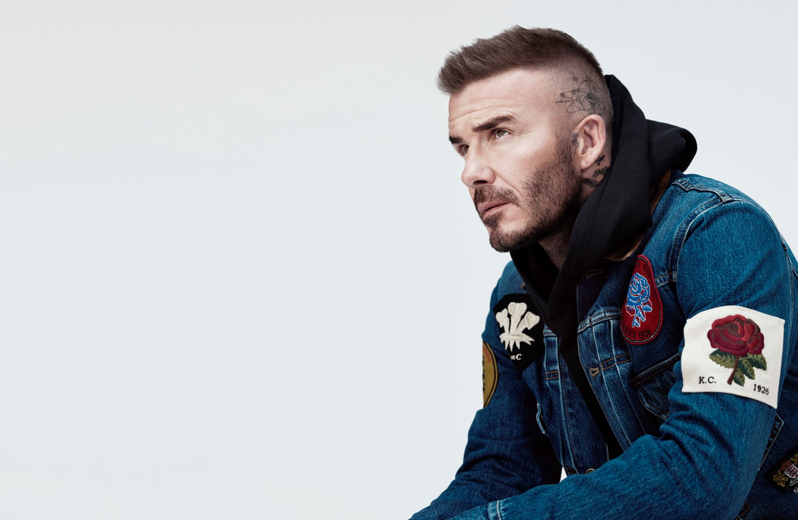 Une image raffinée d'un homme en veste en jean assis sur un tabouret (david beckham, poils du visage, barbe, denim, veste)