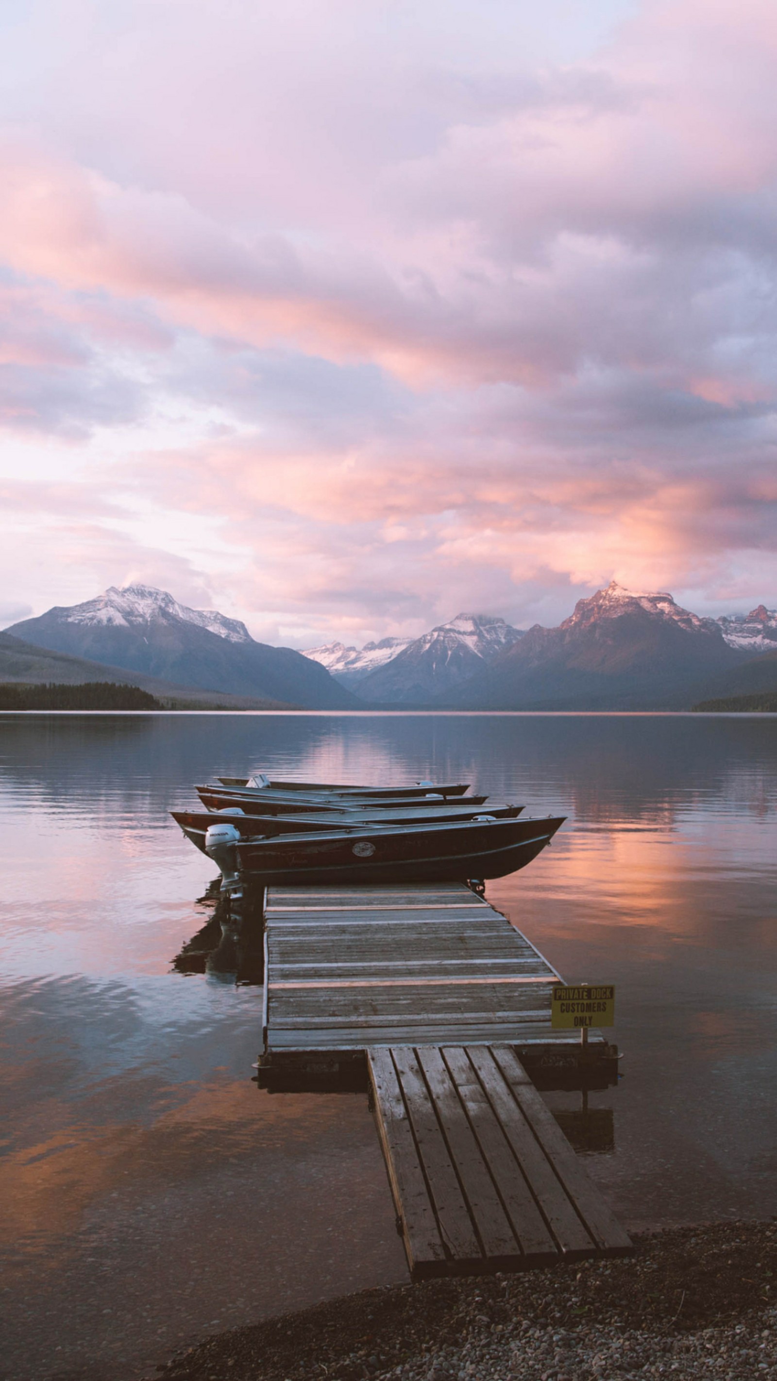 Barcos atracados em um cais em um lago com montanhas ao fundo (reflexo, água, nuvem, montanha, atmosfera)