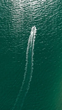 Rippling Waves and a Boat's Wake on Serene Green Waters