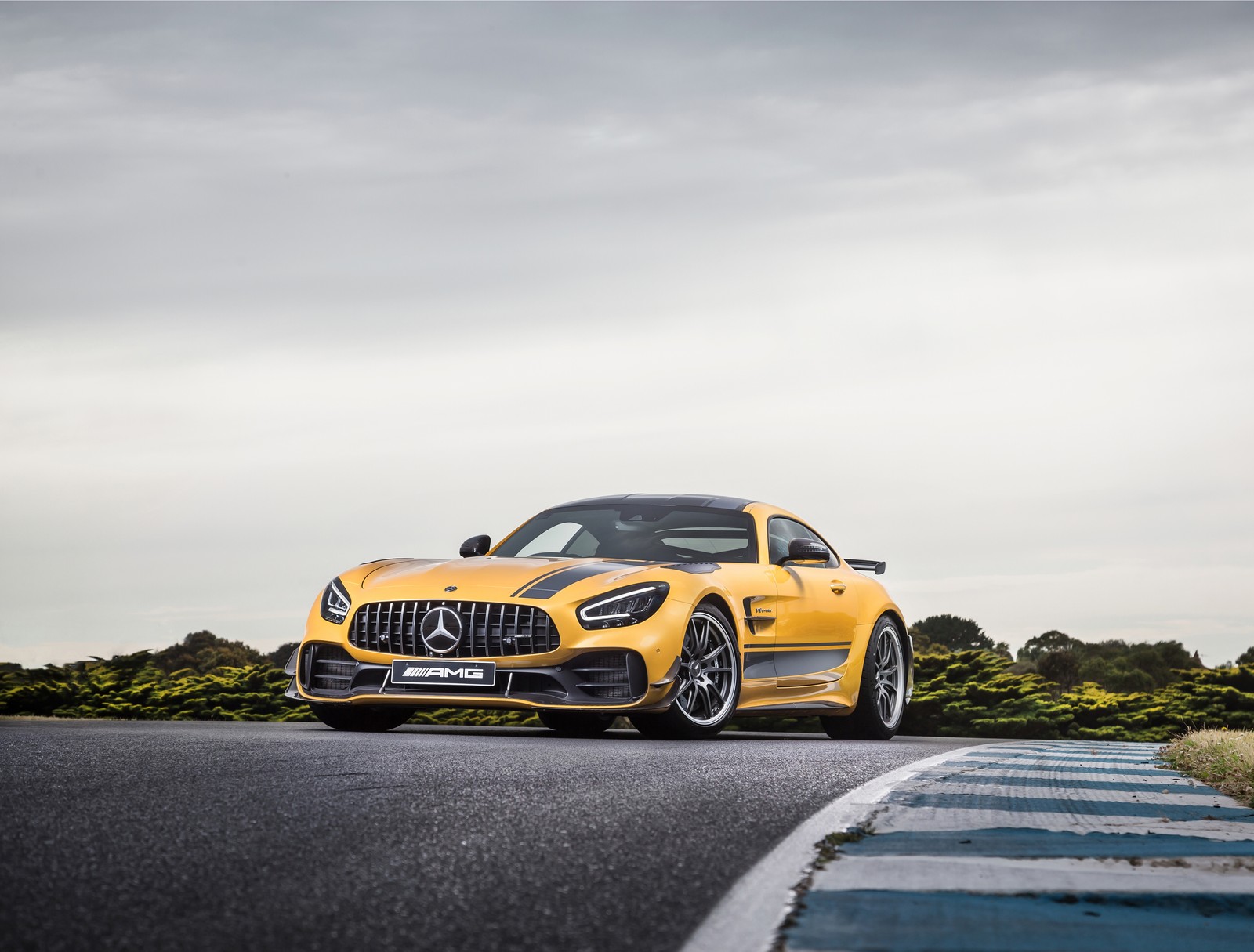 Um carro esportivo amarelo da mercedes dirigindo por uma estrada com céu nublado (mercedes amg gt r pro, 2021, carros, papel de parede 4k)