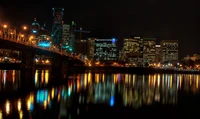 Nächtliche Stadtlandschaft von Portland: beleuchtete Skyline und Reflexionen auf dem Wasser