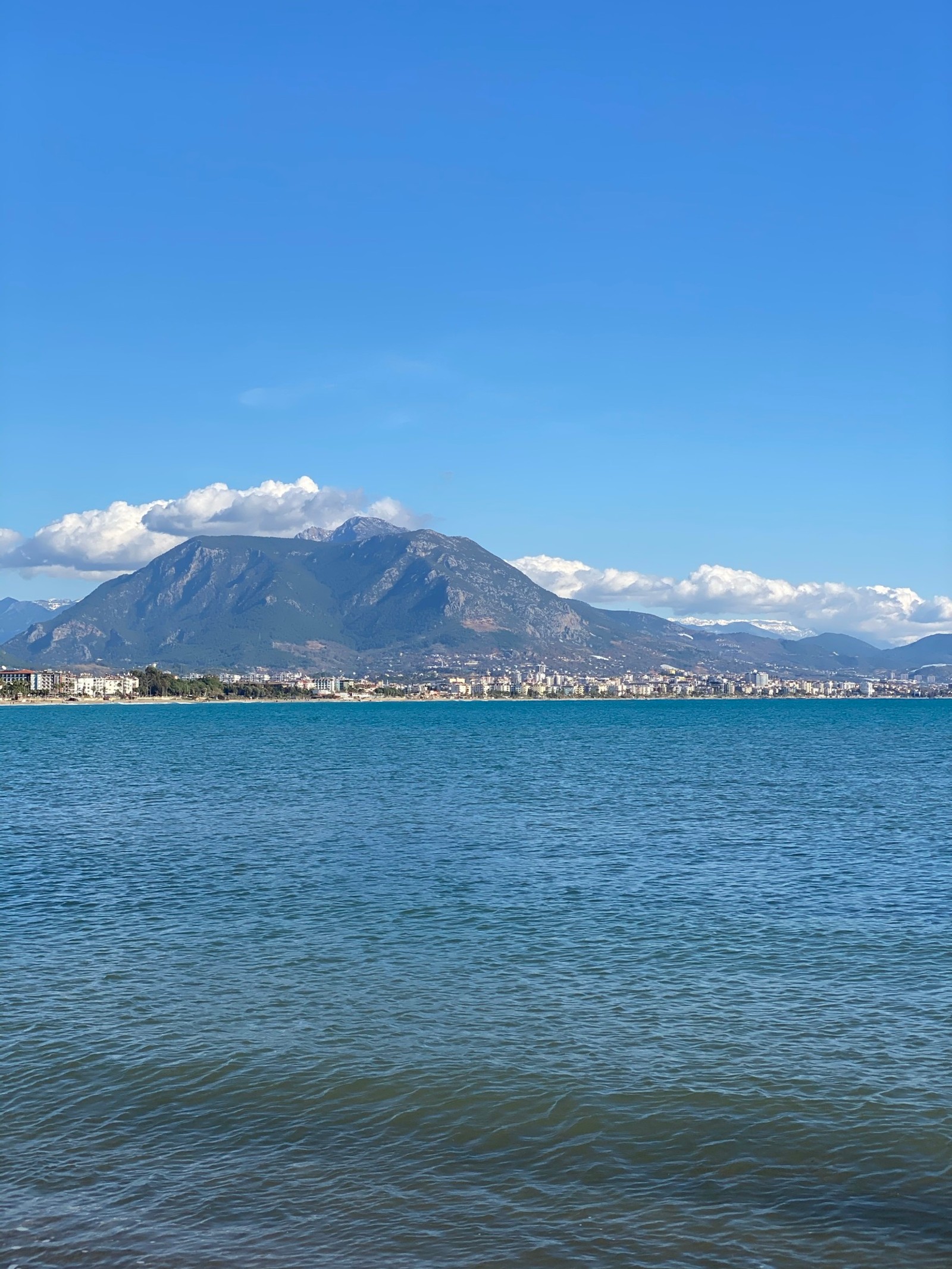 Il y a un grand plan d'eau avec une montagne en arrière-plan (eau, nuage, montagne, lac, banque)