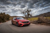 Dinámico Mercedes-Benz E-Class rojo en carretera escénica