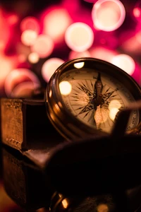 Reflective Compass Surrounded by Soft, Glowing Lights