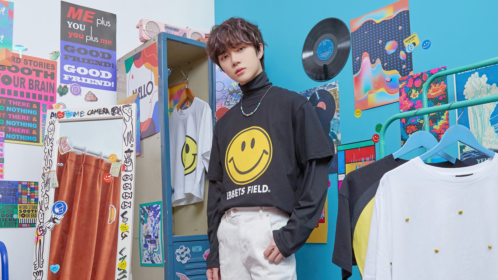 Arabischer mann steht vor einer wand mit einem smiley-t-shirt (txt kpop, tomorrow x together, 투모로우바이투게더, kpop, k pop)