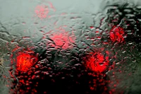 Gotas de lluvia abstractas en vidrio con bokeh rojo