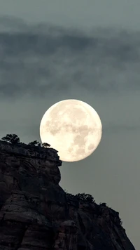 Éblouissant lever de pleine lune sur une crête montagneuse