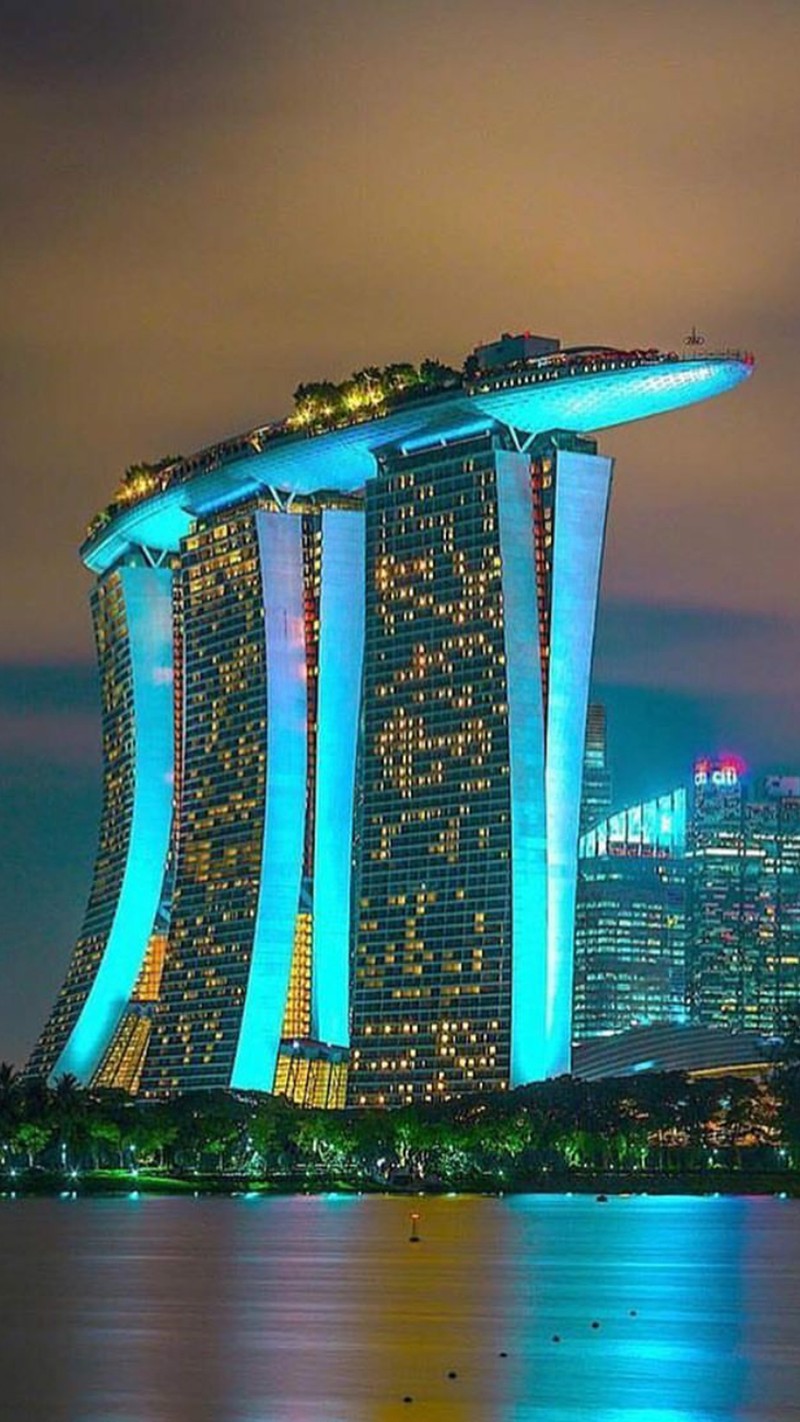 Vue aérienne d'un horizon de ville avec un grand bâtiment illuminé la nuit (ville, singapour)