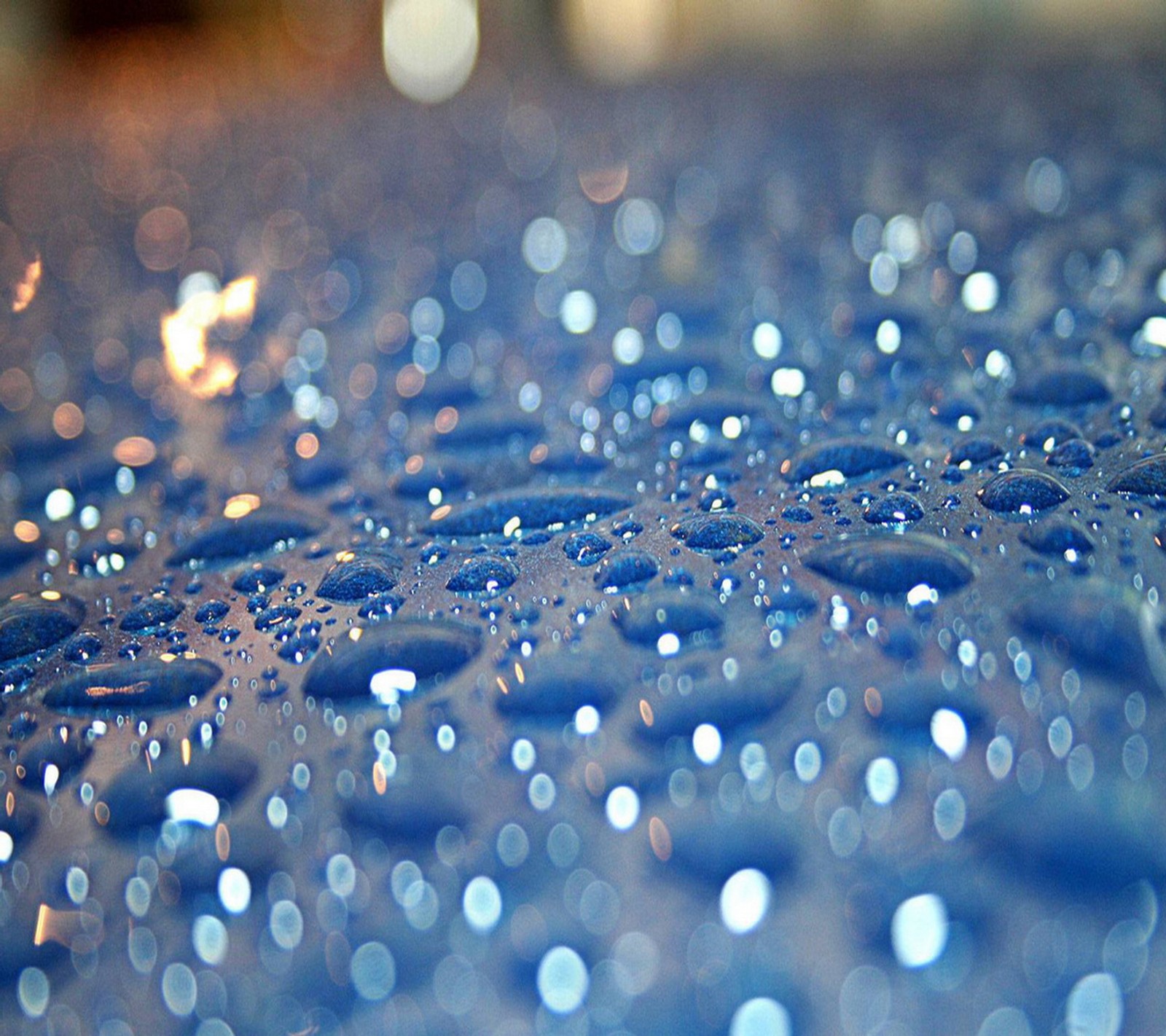 Um close-up de uma mesa azul com gotas de água sobre ela (queda, chuva)