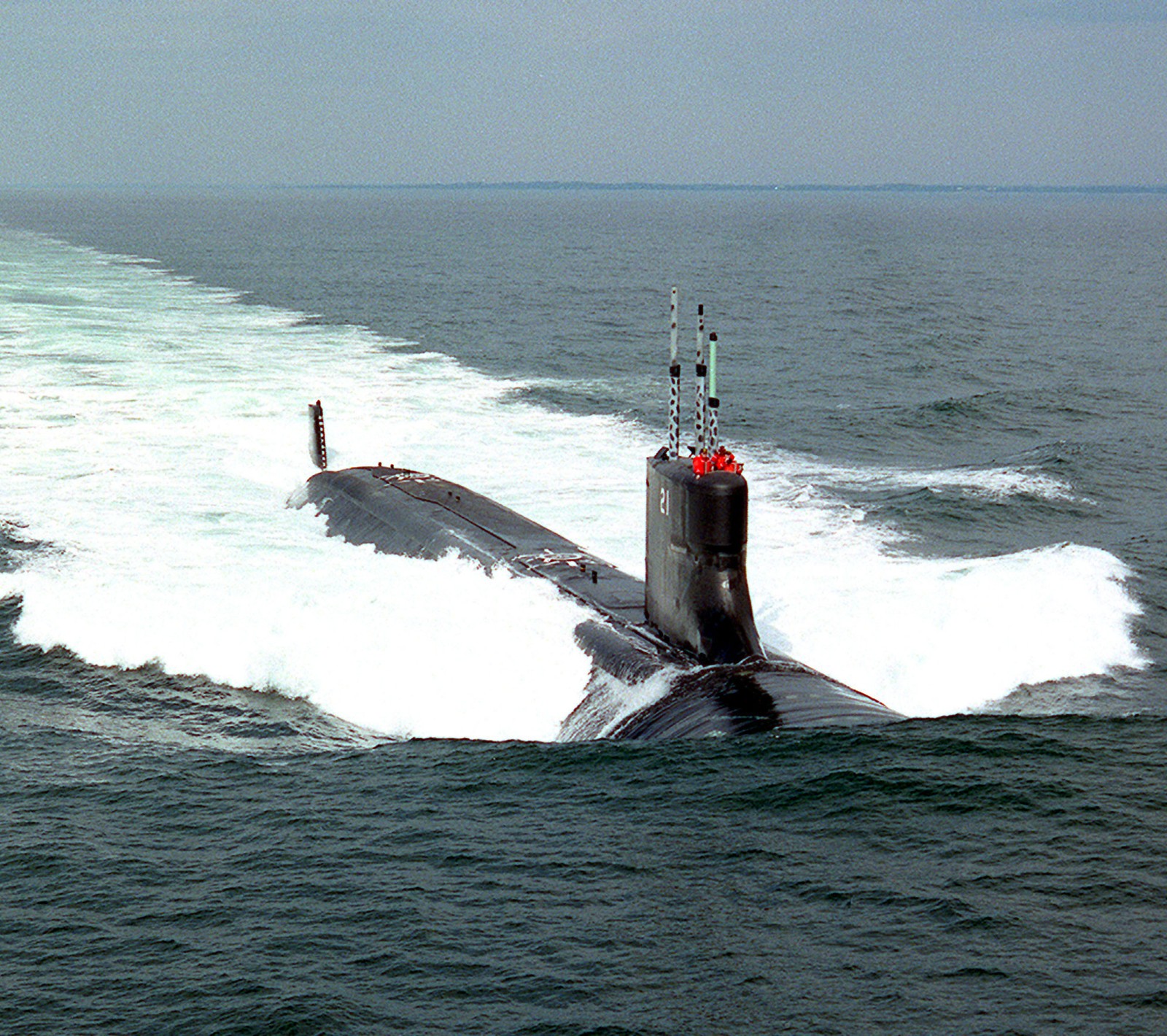 Arafed submarine in the ocean with a man standing on the front of it (military, submarine, vehicle)