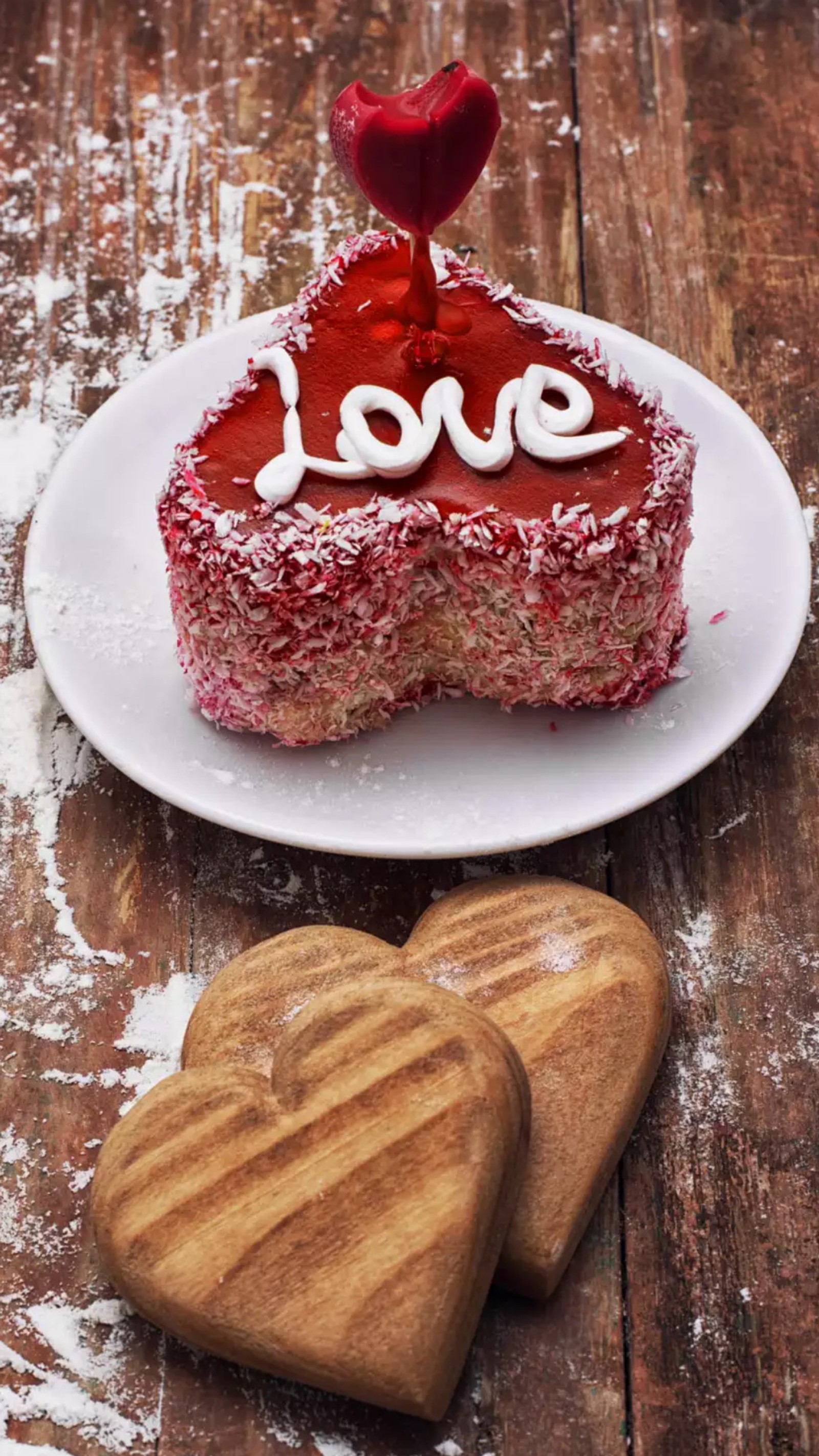 Un morceau de gâteau avec un cœur dessus et deux biscuits (heureux, anniversaire, gâteau, cœurs, rouge)