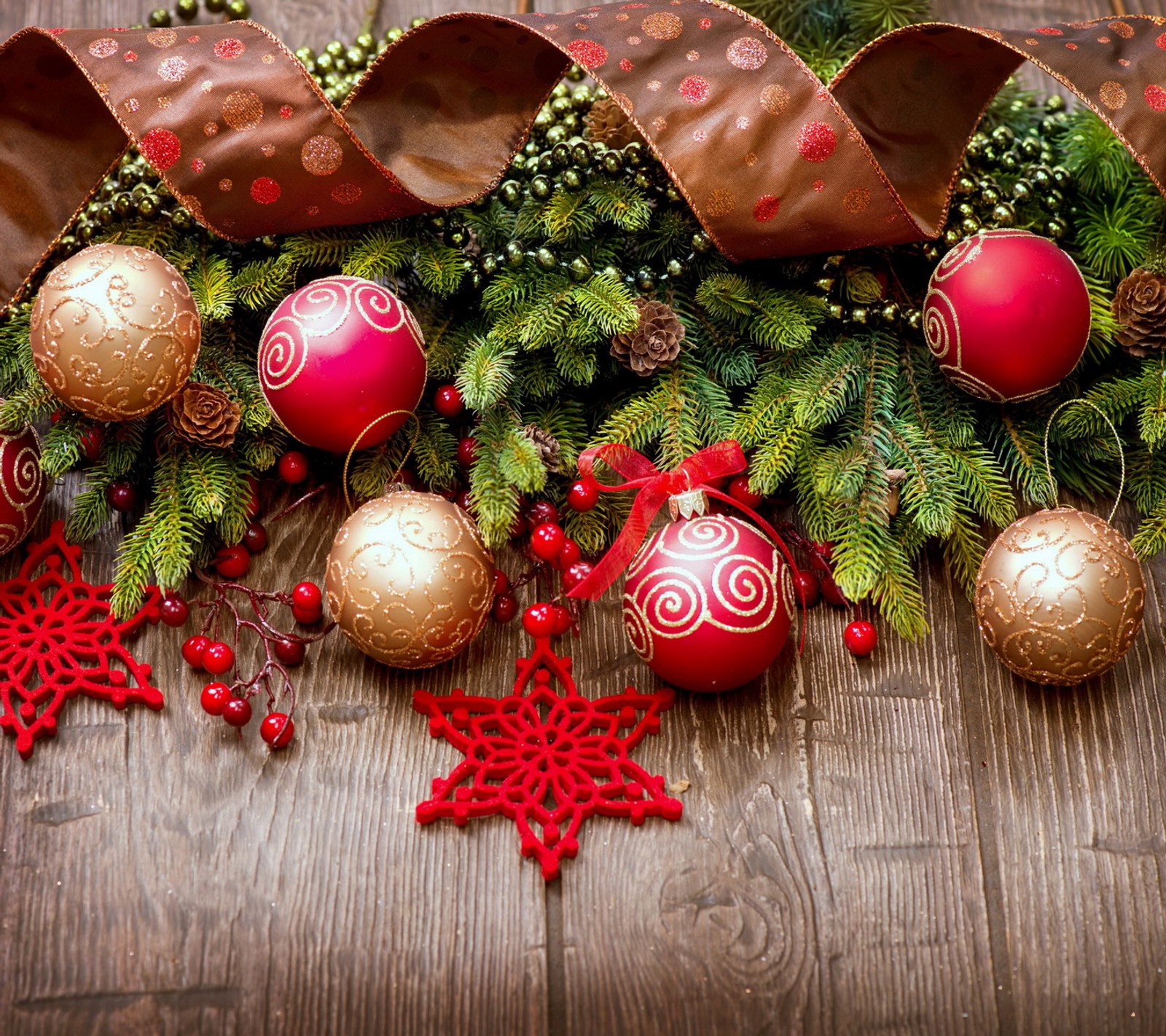 Weihnachtsdekorationen auf einem holztisch mit roten und goldenen ornamenten (bälle, weihnachten, dekoration, fröhlich, holz)