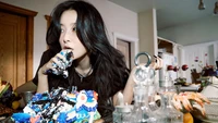 Kang Seulgi enjoying a colorful birthday cake in a vibrant kitchen setting.