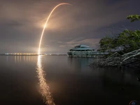 Réflexion du lancement de fusée sur un lac tranquille au crépuscule