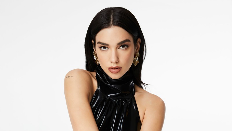 Женщина в черном топе и черных штанах позирует для фотографии (дуа липа, dua lipa, диско поп певец, белый фон, музыка)